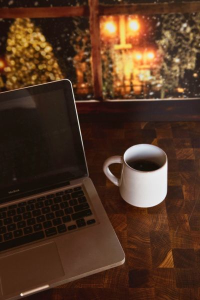 laptop and coffee on the table with a Christmas scene in front