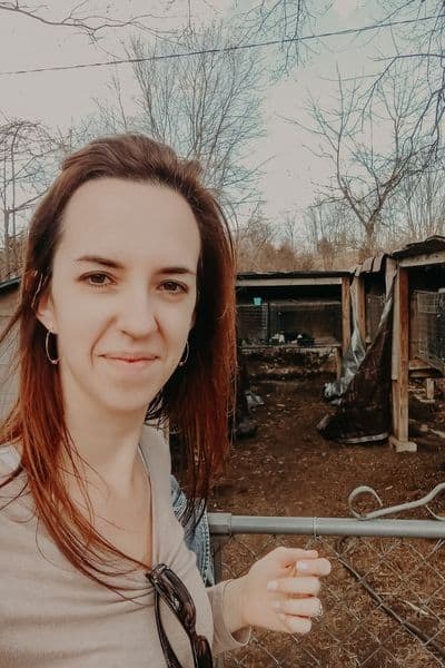 leah lynch standing in front of her rabbitry