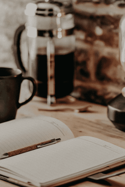 prioritizing tasks header image with a planner, cup of coffee, and french press